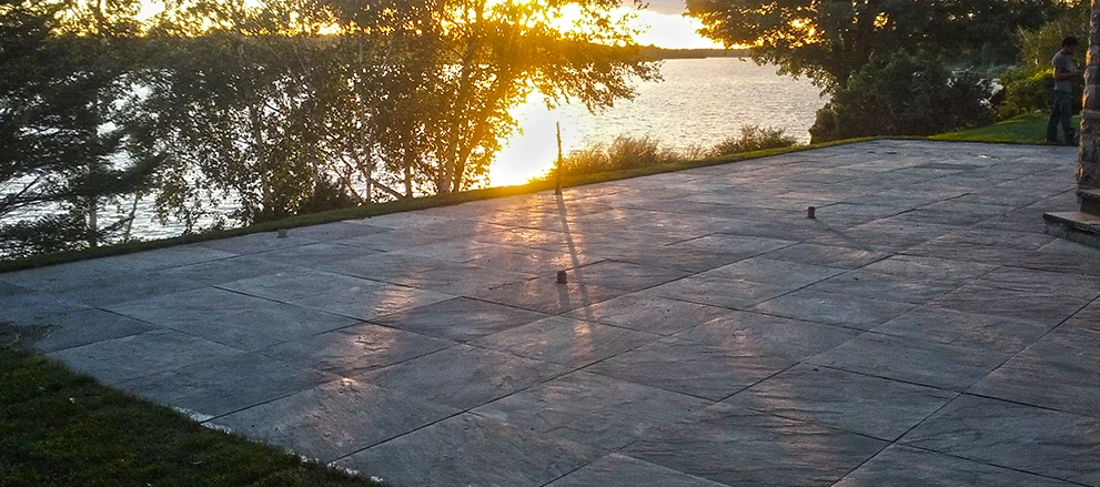 Grand patio de dalles au bord d’un lac au coucher du soleil
